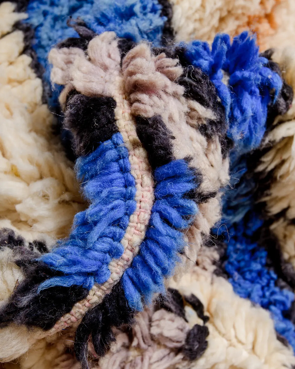Detail of wool Berber rug in shades of cream, blue and black.